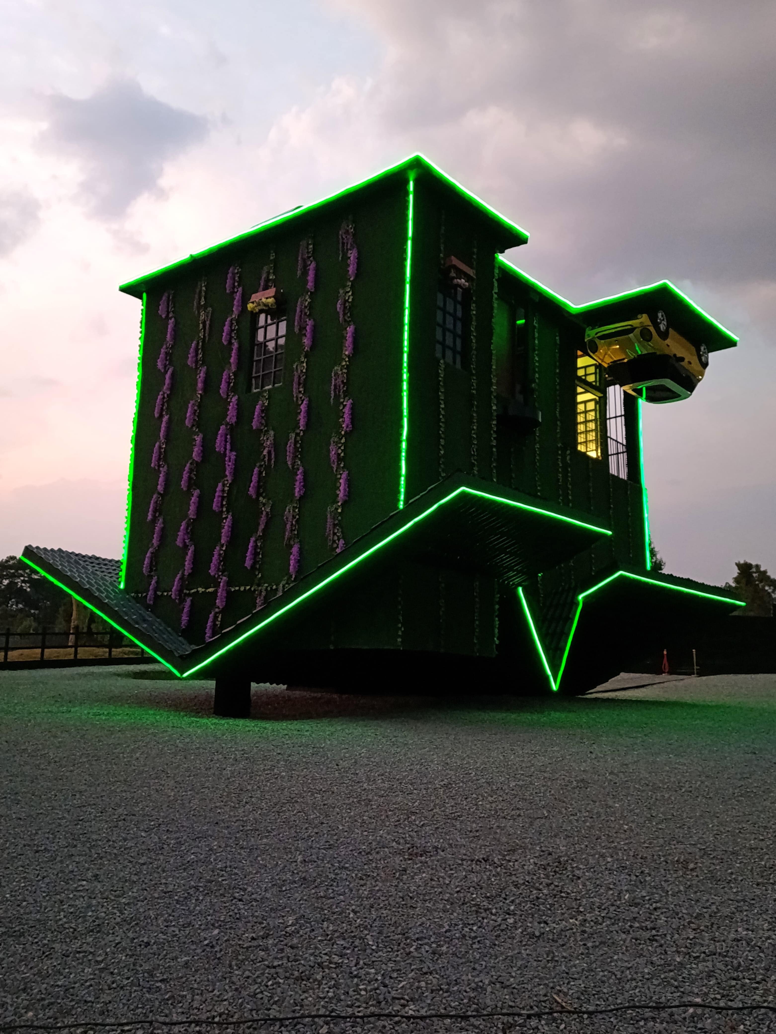 La Chantli, la casa al revés del Rancho Nochi Noyollo, iluminada con neón verde al atardecer